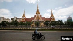 រូប​ឯកសារ៖ បុរស​ម្នាក់​បើក​ម៉ូតូ​កាន់​តាម​ផ្លូវ​ភ្លោះ​មុខ​រដ្ឋសភា​កម្ពុជា​ក្នុង​រាជធានី​ភ្នំពេញ កាល​ពី​ឆ្នាំ​២០១៤។