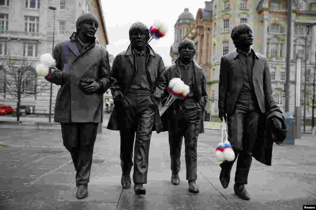 Statues of The Beatles are holding "tickling sticks" — comedian Ken Dodd's quintessential prop — ahead of Dodd's funeral in his hometown of Liverpool, Britain.