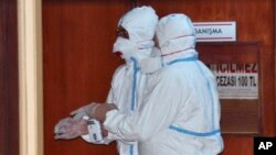 In this photo taken April 5, 2017 and made available April 6, World Health Organization experts work as they take part in an autopsy conducted in a hospital in Adana, Turkey. 