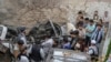 30일 아프가니스탄 카불의 한 집에서 미군의 드론 공습으로 파괴된 것으로 보이는 차량 주변에 사람들이 모여있다.