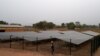 Un ingénieur se tient à côté d'une clôture protégeant un panneau solaire installé dans le village de Takpapieni dans la province d'Oti, au nord du Togo, le 14 février 2020. (Photo AFP/ PIUS UTOMI EKPEI)