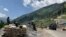 FILE - Indian paramilitary soldiers keep guard as an Indian army convoy moves along the Srinagar-Ladakh highway at Gagangeer, India, June 18, 2020, as a standoff between India and China over the Himalayan Galwan Valley escalates.