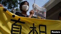 在西九龙法院的一次听证期间，一名支持者举着报纸在法院外声援《苹果日报》。(2021年6月19日)
