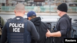 FILE - U.S. Immigration and Customs Enforcement officers detain a suspect in Los Angeles, Feb. 7, 2017.