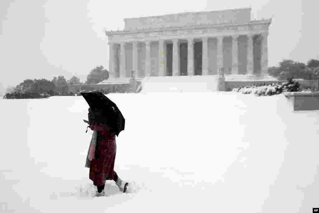Un femme marche dans la neige devant le Lincoln Memorial à Washington DC, le 23 janvier 2016.(AP Photo/Alex Brandon)