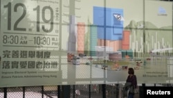 一名妇女走过香港立法会换届选举的广告