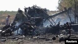 مردی در حال بررسی یک خمپاره‌انداز هویتزر ارتش اوکراین – حومه بندر ماریوپل، ۱۵ شهریور ۱۳۹۳