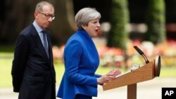 9일 테레사 메이 영국 총리가 런던 다우닝 10번가 총리
관저에서 성명을 발표하고 있다. 남편 필립 메이가 이를 지켜보고 있다.