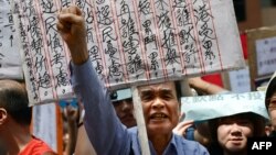 A demonstrator shouts during a protest to denounce the governments voting system outside the venue where a 1,200-member election committee are to choose the city's new leader, in Hong Kong, March 25, 2012. 
