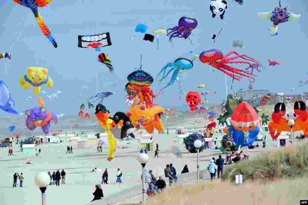 Orang-orang menerbangkan layang-layang dalam festival layang-layang internasional di Berck-sur-Mer, Perancis utara, 13 April 2013. 