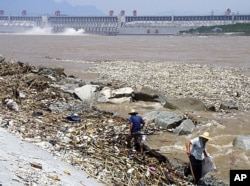 2010年8月，工人在三峡大坝附近清理洪水带来的垃圾