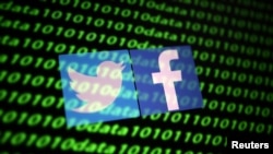 FILE - The Twitter and Facebook logos are seen with binary cyber codes in this illustration photo taken Nov. 26, 2019. 