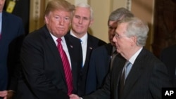 资料照片：时任美国总统的特朗普与时任副总统的彭斯离开参议院共和党政策午餐会时与时任参议院多数党领袖的麦康奈尔握手。(2019年1月9日)