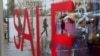 People reflected in a shop window with a "Sale" sign as they cross a road in downtown Moscow, Feb. 5, 2016.