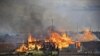 A machinegun-mounted truck manned by members of the Sudan Armed Forces (SAF) drive past burning businesses and homesteads in the center of Abyei, central Sudan in this handout photograph released by United Nations Mission in Sudan on May 28, 2011
