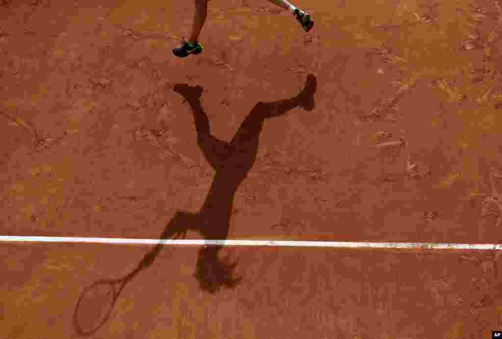 Canada&#39;s Eugenie Bouchard casts a shadow on the clay as she plays Japan&#39;s Risa Ozaki during their first round of the French Open tennis tournament at the Roland Garros stadium in Paris, France.