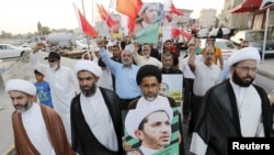 Des manifestants tiennent des pancartes avec le visage de Sheikh Ali Salman, le principal leader et secrétaire général de Al-Wefaq, dans le village de Jidhafs, à l'ouest de Manama, Bahreïn,16 juin 2015.