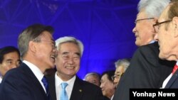 문재인 한국 대통령(왼쪽)이 24일 전북 무주군 태권도원 T1 경기장에서 열린 '2017 무주 WTF 세계태권도선수권대회' 개막식에 참석해 북한의 장웅 국제올림픽위원회(IOC) 위원과 악수하고 있다.