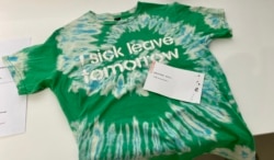 香港市民Phoenix 在反送中运动两周年义卖活动，以物易物方式带走一件喻意饮水思源的T恤。 (美国之音 汤惠芸拍摄)