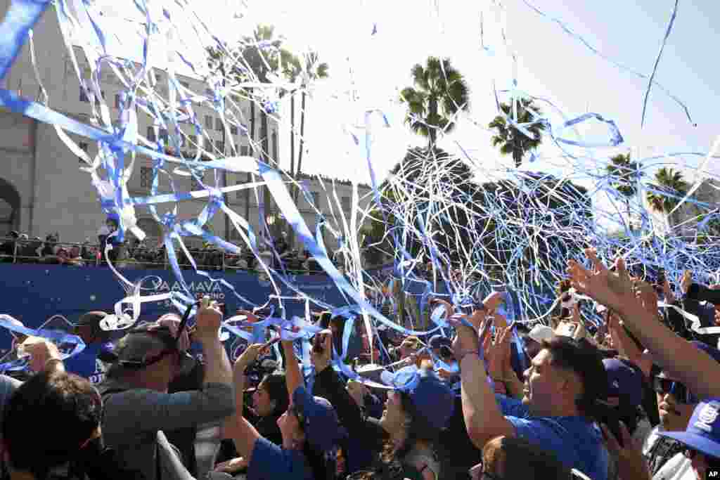 Fans cheer as buses carrying players drive by during the Los Angeles Dodgers baseball World Series championship parade in Los Angeles.