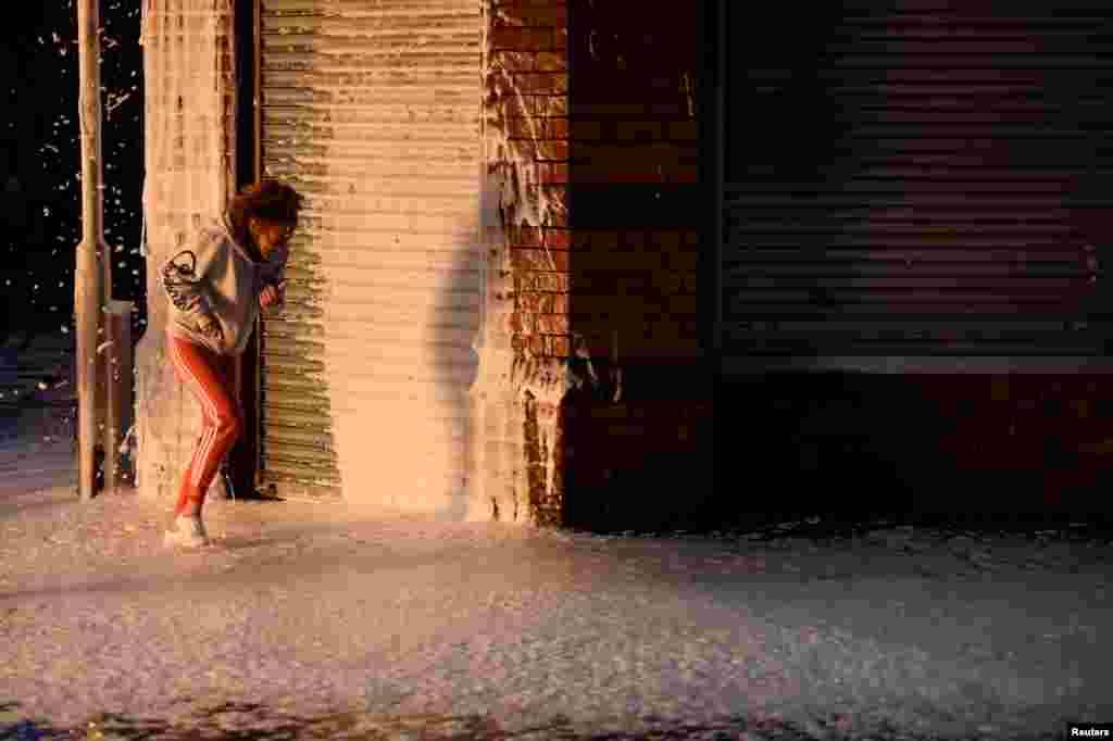 ស្រ្តី​ម្នាក់​រត់កាត់​ហ្វូម​បាញ់​ដោយ​អ្នក​ពន្លត់អគ្គិភ័យ​ដើម្បី​ទប់ទល់​នឹង​គំនរ​ភ្លើង​មួយ​នៅ East Belfast មុន​ថ្ងៃ១២ កក្កដា ២០១៧ រៀបចំ​ដោយ​សមាជិក Loyalist Orders ក្នុង​ទីក្រុង Belfast ភាគ​ខាងជើង​ប្រទេស​អៀរឡង់ កាល​ពីថ្ងៃទី​១១ កក្កដា ២០១៧។​​