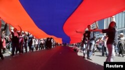 Lebanese Armenians carry an Armenian national flag as they march in North Beirut, April 24, 2015.