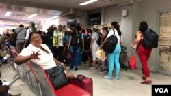 Cuban tourists line up to board their flight at the Toussaint Louverture airport in Port-au-Prince, Haiti. (S. Lemaire/VOA) 