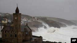 FILE - Powerful waves break on the shoreline around the small port of Porthleven, south west England, Feb. 16, 2020. 