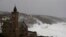 FILE - Powerful waves break on the shoreline around the small port of Porthleven, south west England, Feb. 16, 2020. 