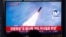 People watch a TV broadcasting file footage for a news report on North Korea firing an unidentified projectile, in Seoul, South Korea, Nov. 28, 2019.