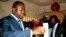 FILE - President of Togo Faure Gnassingbe (L) casts his ballot inside a school in Lome Jul. 25, 2013.