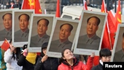 中国山西省太原一所大学的学生手举中共前领导人毛泽东的画像庆祝毛泽东诞辰120周年。（资料照片）
