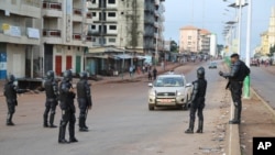 Des policiers à un point de contrôle à Conakry, lors de la présidentielle en Guinée, le 11 octobre 2015.
(AP Photo/Youssouf Bah)
