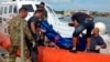 The body of a drowned migrant is being unloaded from a Coast Guard boat in the port of Lampedusa, Italy, Oct. 3, 2013. 