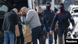 Police look at bags of evidence material during a search in the Brussels borough of Schaerbeek following Tuesday's bombings in Brussels, Belgium, March 25, 2016. 