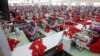 This photo taken on Aug. 30, 2017 shows garment workers sewing clothes in a factory as they wait for visit by Prime Minister Hun Sen outside of Phnom Penh, Cambodia.