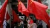 FILE - China supporters march with Chinese national flags during a rally to mark the 18th anniversary of Hong Kong's handover to China, in Hong Kong, July 1, 2015.