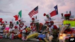 Flags fly over crosses at a makeshift memorial near the scene of a mass shooting, Aug. 4, 2019, at a shopping complex, Aug. 6, 2019, in El Paso, Texas. 