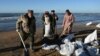 Волонтеры убирают разлитую нефть вдоль береговой линии. Поселок Витязево, недалеко от черноморского курорта Анапа. Россия. 20 декабря 2024г.. REUTERS/Sergey Pivovarov.