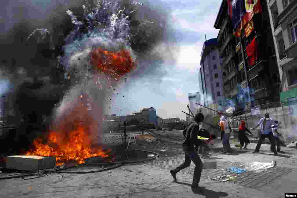 Para pengunjuk rasa berlari setelah terjadi ledakan dalam aksi anti-pemerintah di Lapangan Taksim, Istanbul, Turki.