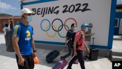 2022年冬季奥运会一年后将在北京举行，目前，超过180个机构呼吁各国政府抵制这场赛事。图为到河北省张家口崇礼的游客走过北京2022冬季奥运会的广告牌。（美联社2020年8月13日资料照）