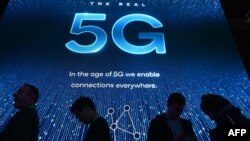  2019年电子消费展在拉斯维加斯会展中心举行，与会者在高通展台前排队等待5G展示。