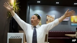 奥米尔贝卡利在哈萨克斯坦首都阿拉木图接受采访时展示他在中国当局的拘留营里是怎样被吊起来的。（2018年3月29日）