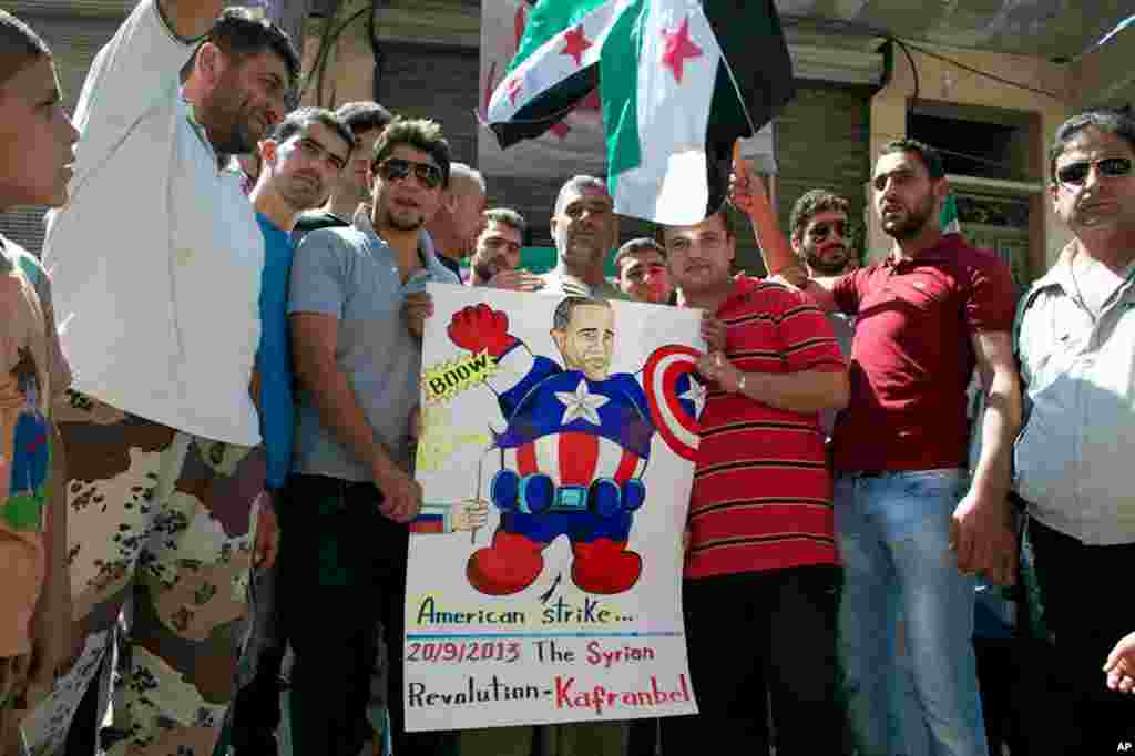 This citizen journalism image provided by Edlib News Network shows anti-Syrian regime protesters hold a poster depicting U.S. President Barack Obama during a demonstration in Kafr Nabil, Idlib province, Sept. 20, 2013.
