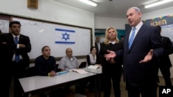 Perdana Menteri Israel Benjamin Netanyahu didampingi istrinya Sara saat berbicara di media setelah memberikan suara dalam pemilu di Yerusalem (17/3). (AP/Sebastian Scheiner, Pool)