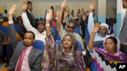 Somalia lawmakers raise their hands during a confidence vote on Prime Minister Abdiweli Sheikh Ahmed, at the Parliament Building in Mogadishu, Somalia, Dec. 6, 2014.
