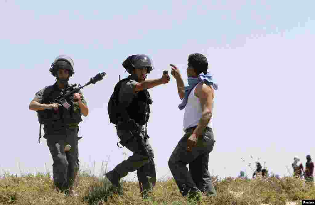 Seorang polisi perbatasan Israel menggunakan semprotan merica ke arah seorang pria Palestina dalam bentrokan antara pemukim Yahudi dan Palestina di desa Urif, dekat Nablus,Tepi Barat.