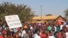FILE - Demonstrators march along a street protesting May election results during a rally in Malawi's capital Lilongwe. Despite the coronavirus spread, a re-run of the vote is now scheduled for July. (Lameck Masina/VOA)