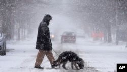 انریکه داویلا در حالی که برف سنگینی در روز یکشنبه، ۱۶ دی ۱۴۰۳، در شهر سنت لوئیس می‌بارد، به همراه سگش، چولا، از خیابان عبور می‌کند. 