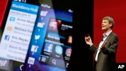 Thorsten Heins, president and CEO at BlackBerry holds up the new BlackBerry 10 mobile device at a conference, May 14, 2013, in Orlando, Florida.